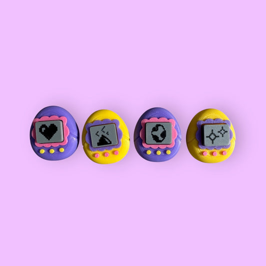 Four colorful vintage-style toys with screen displays on a pink background