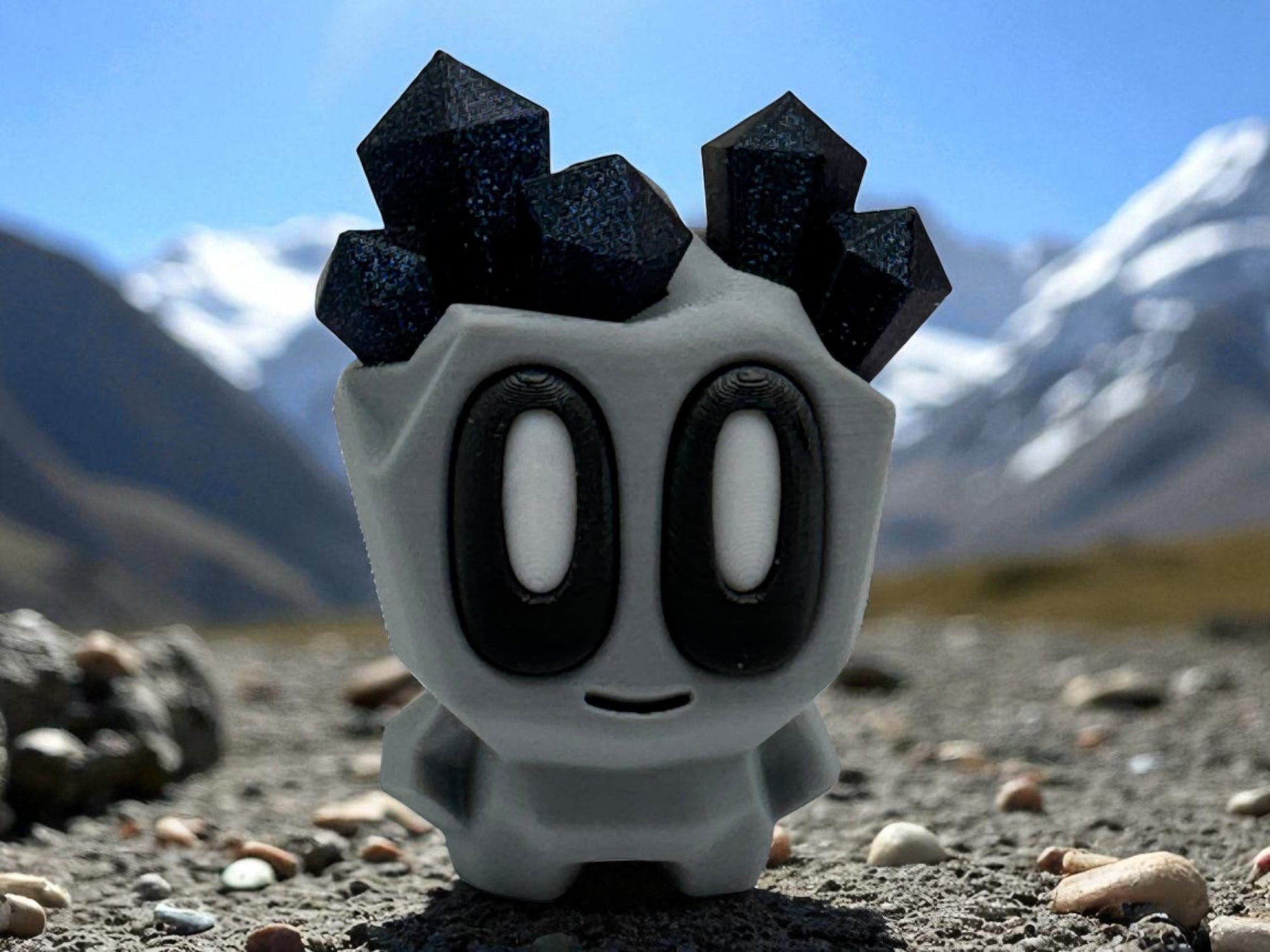 Toy figure with black spikes on a rocky landscape with mountains in the background