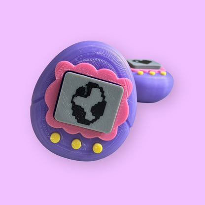 Purple toy with pink accents and a black square on a pink background