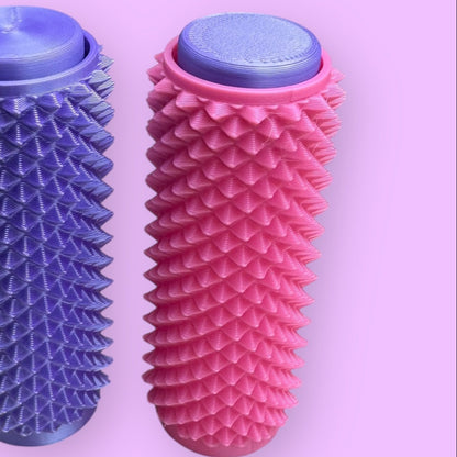 Two textured massage rollers, one blue and one pink, on a pink background
