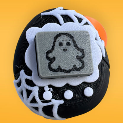 Decorative button with ghost design on a yellow background