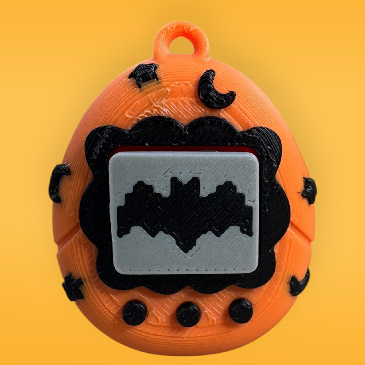 Halloween-themed keychain with orange pumpkin design, black bats, and gray center on a yellow background