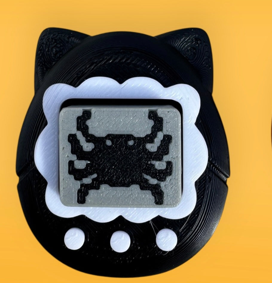 Two black cat-shaped digital toys with pixelated designs on a yellow background